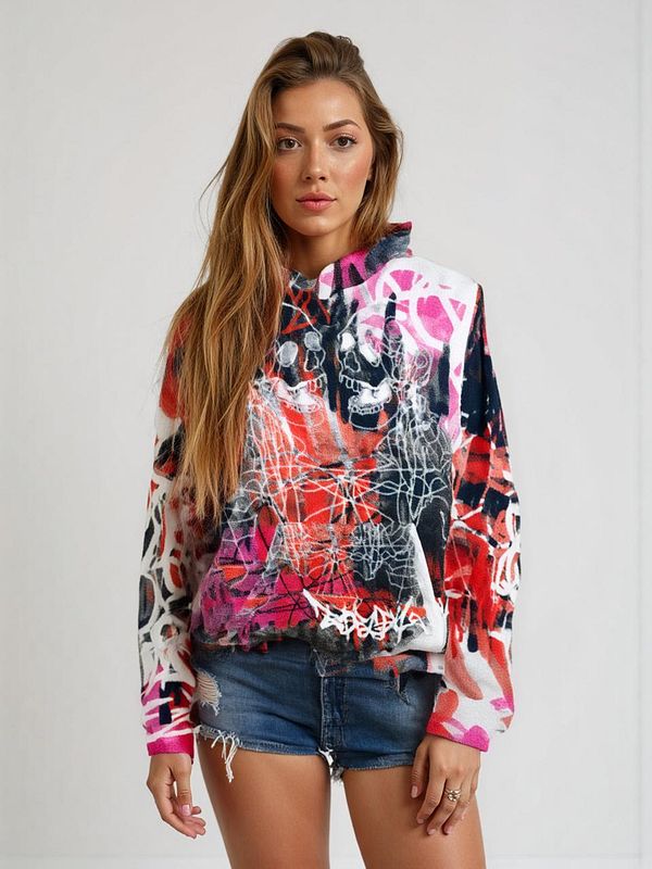 A model showcases a vibrant, graffiti-style hoodie paired with denim shorts.