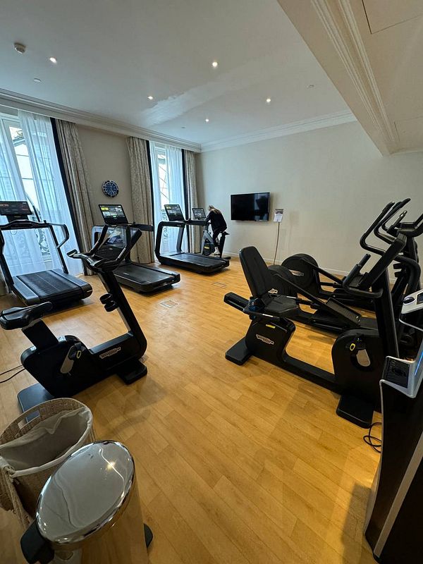 A modern gym space featuring various exercise equipment.