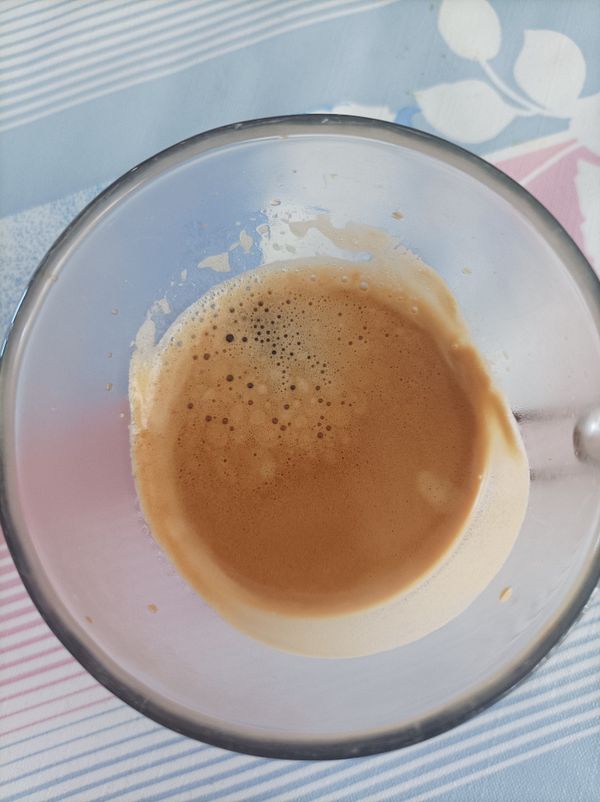 A close-up view of a glass containing freshly brewed espresso.