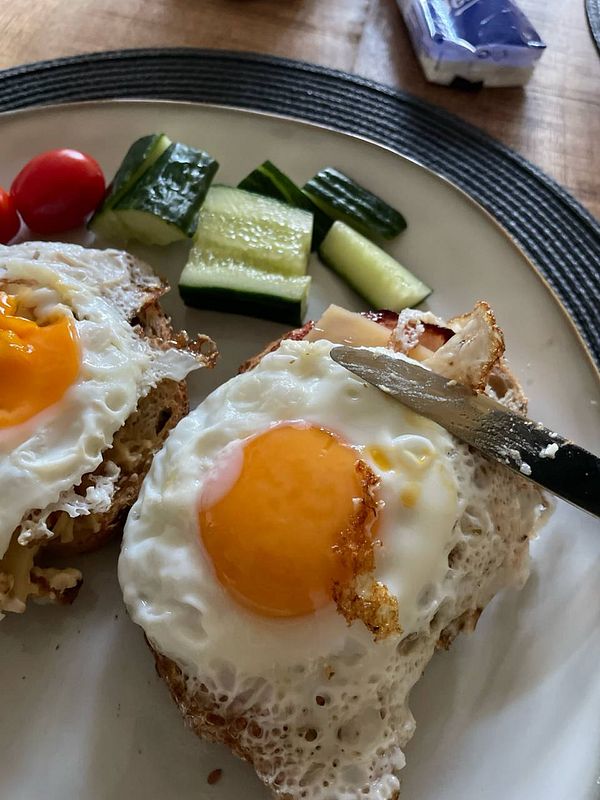 A nutritious protein meal featuring fried eggs on toast with vegetables.