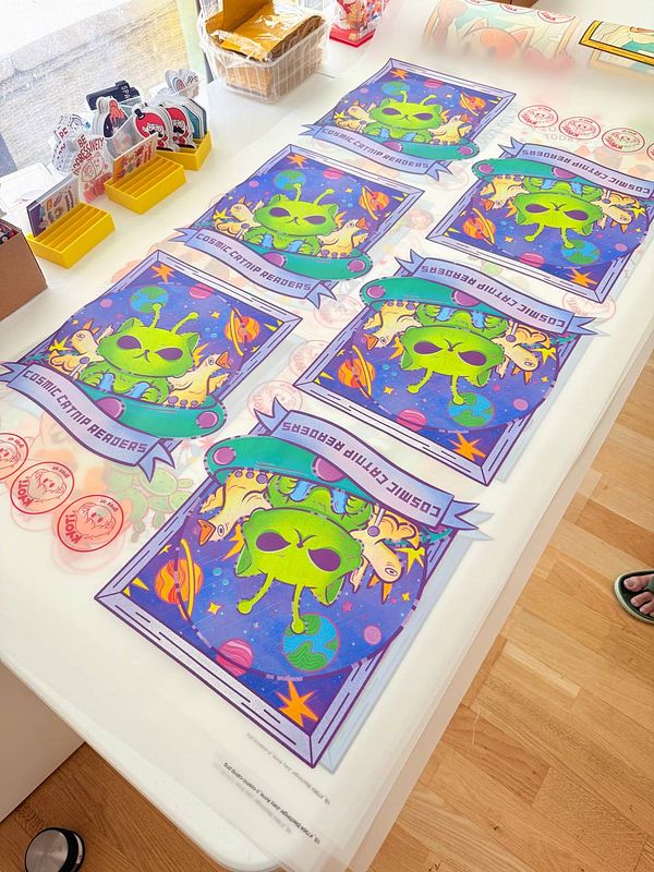 Flat lay of multiple colorful enamel pins on a wooden surface showing various characters and designs.