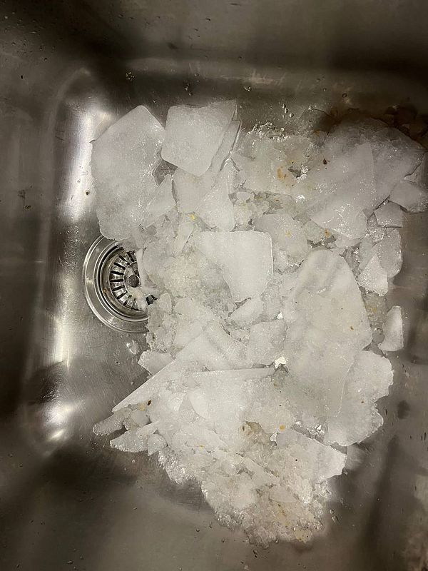 A sink filled with large chunks of ice and water.