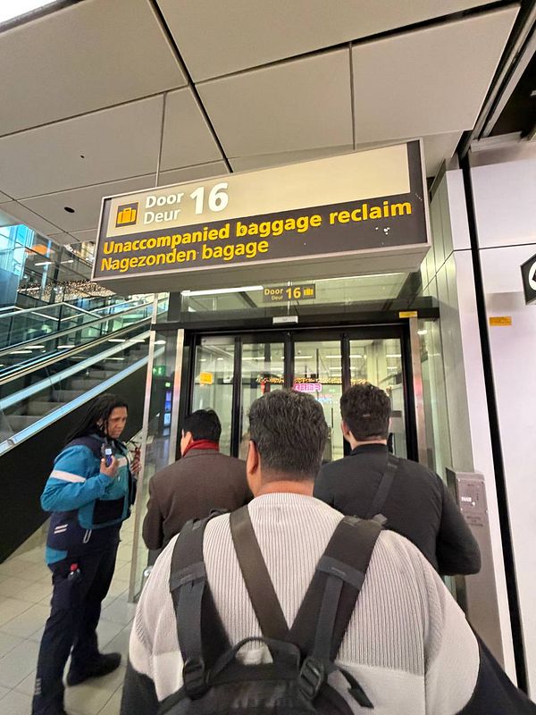 Passengers are waiting at Door 16 for unaccompanied baggage reclaim at Amsterdam Schiphol Airport.