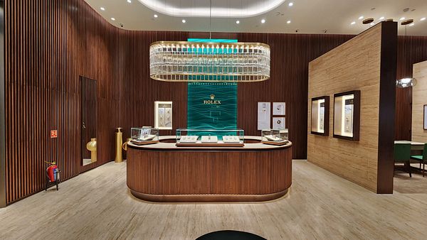 A luxurious interior of a Rolex boutique featuring elegant wooden finishes and display cases.