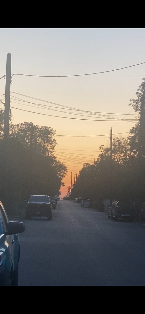 A street in San Antonio is illuminated by a vibrant sunset.