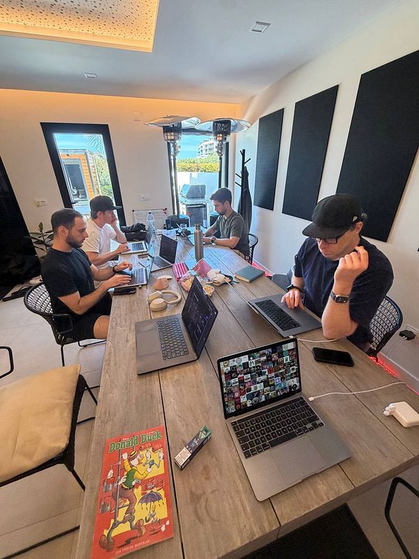 Illustration of people working together on laptops and coffee cups on a table.