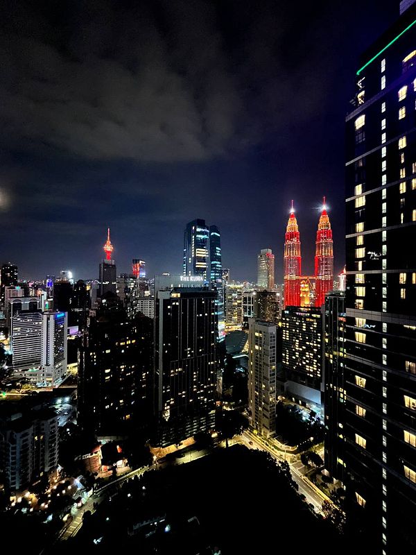 A stunning night view of Kuala Lumpur's skyline featuring the iconic Petronas Twin Towers.