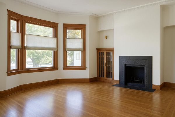 A spacious, well-lit living room featuring large windows and a fireplace.