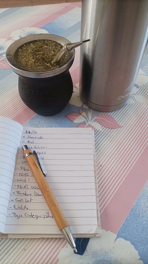 A cozy workspace featuring a traditional mate setup alongside a notebook and pen.