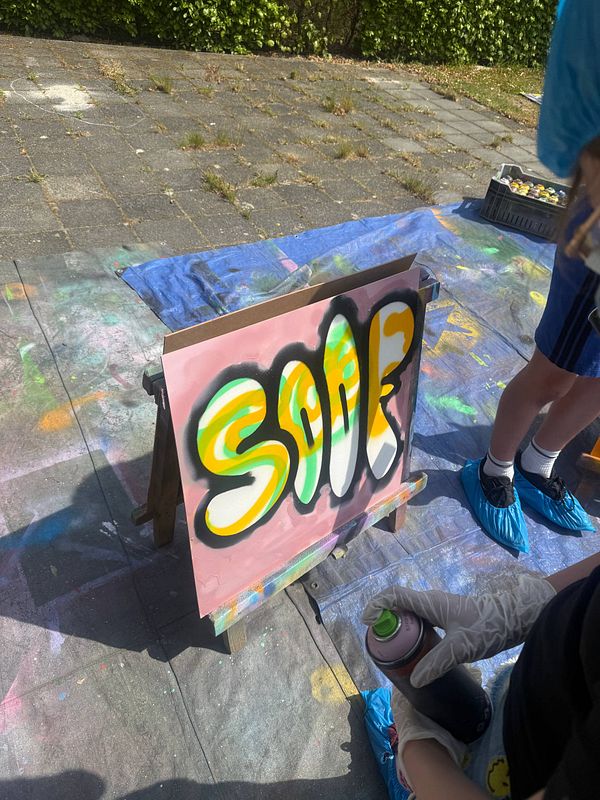 A vibrant and colorful wall covered in various graffiti art styles, with kids actively participating in a graffiti workshop.
