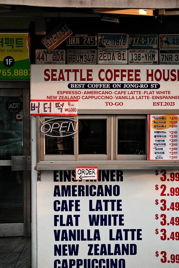 A tranquil natural scene of a lake reflecting tall pine trees under a pastel morning sky