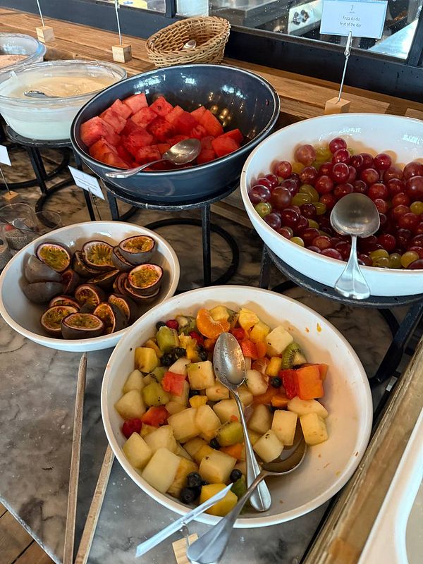 A buffet-style breakfast display featuring various fruit options.