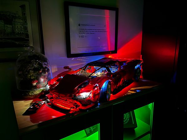 A detailed model of a Ferrari SP3 is illuminated with LED lights, showcasing its intricate design.