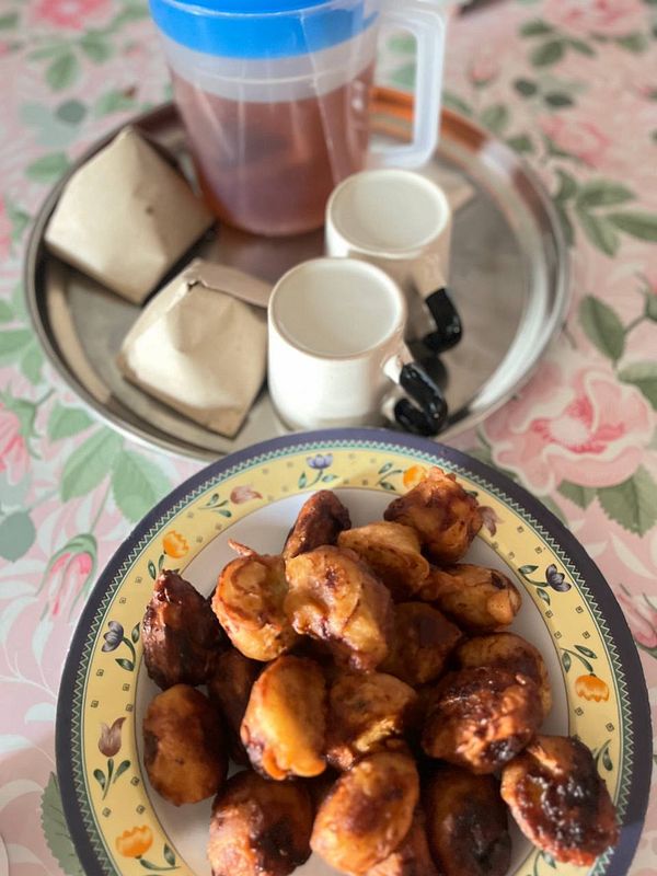 A traditional breakfast spread featuring fried snacks and tea.