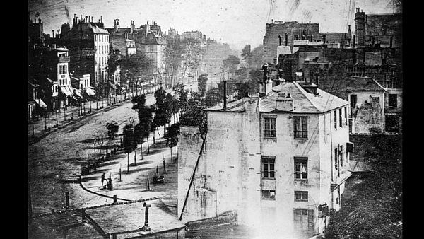 A historic black-and-white photograph of a Paris street scene from 1838.