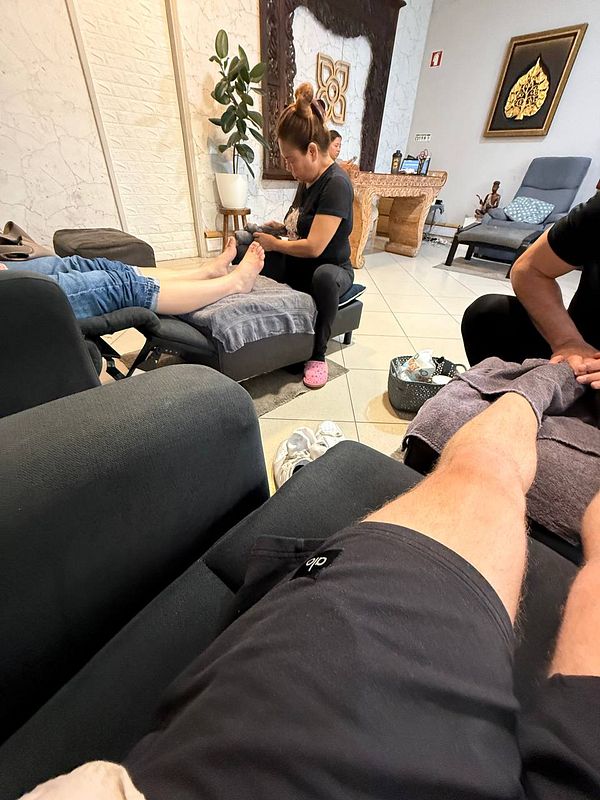 A foot massage session is taking place in a relaxing spa environment.