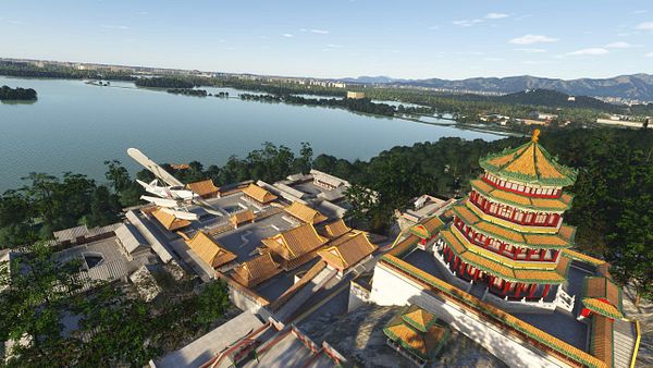 A scenic aerial view of a traditional Chinese architectural site near a lake, with a small airplane nearby.