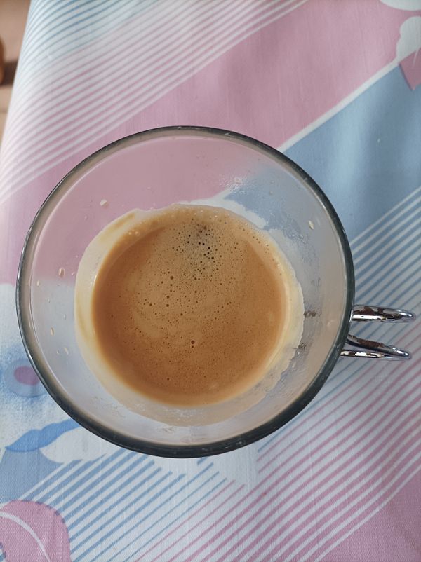 A close-up view of a glass containing a small amount of espresso.