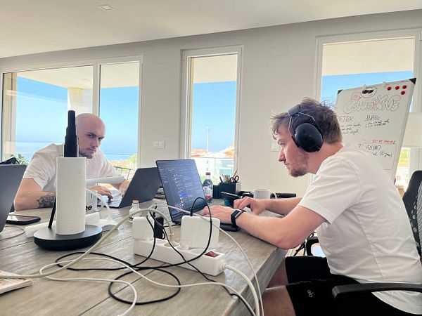 Two individuals are working at a modern coworking space with a view.