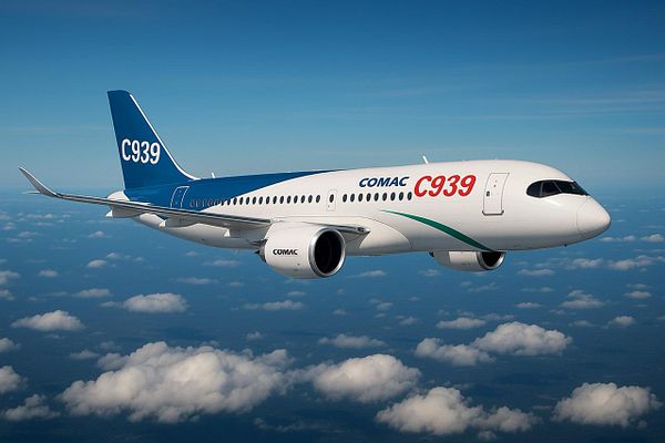 A COMAC C939 aircraft is flying above a cloud-covered landscape.