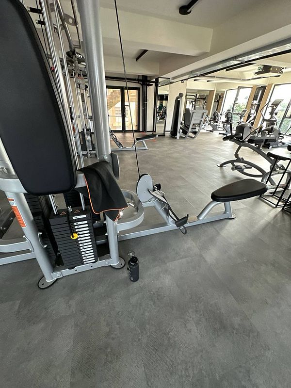 A well-equipped gym space featuring exercise machines and a water bottle.