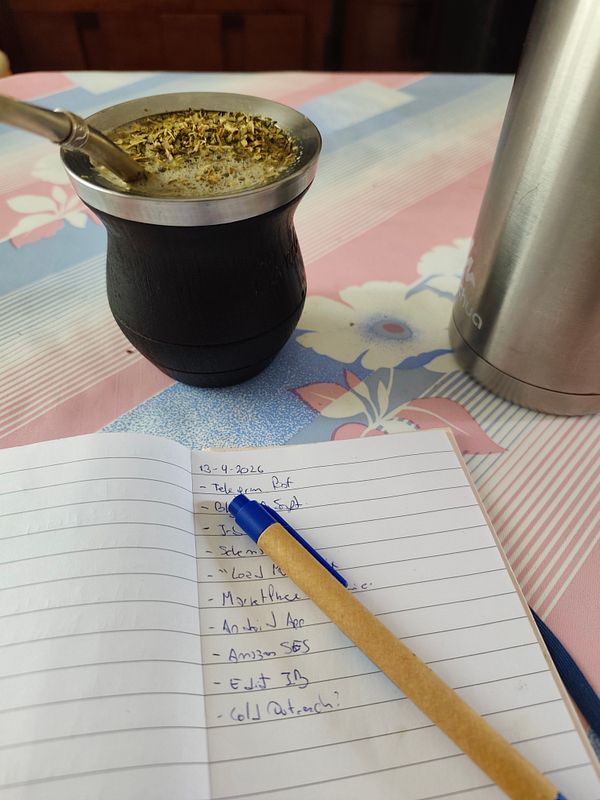 A minimalist workspace with a laptop displaying a calendar, surrounded by coffee and stationery items, capturing a productive Monday morning setup.