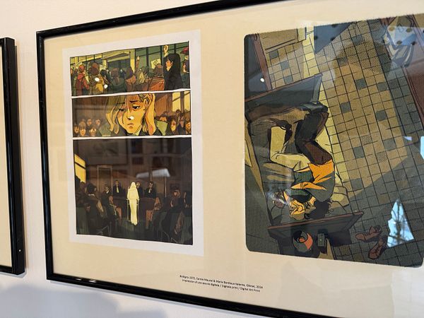 The image features a framed artwork consisting of a comic-style illustration divided into three panels.