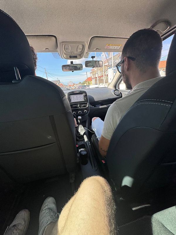 The image captures the interior of a car during a driving lesson.