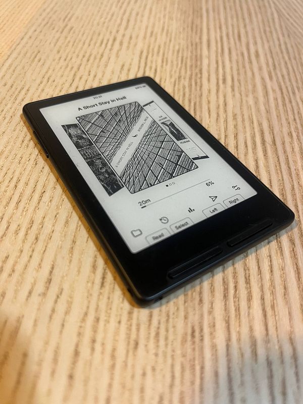 Top-down view of an e-ink device displaying a text document specifying a task to install open source firmware.
