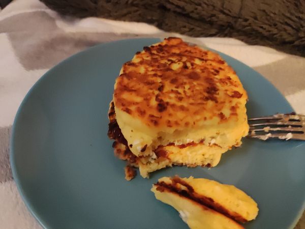 A protein pancake with cottage cheese is displayed on a blue plate.