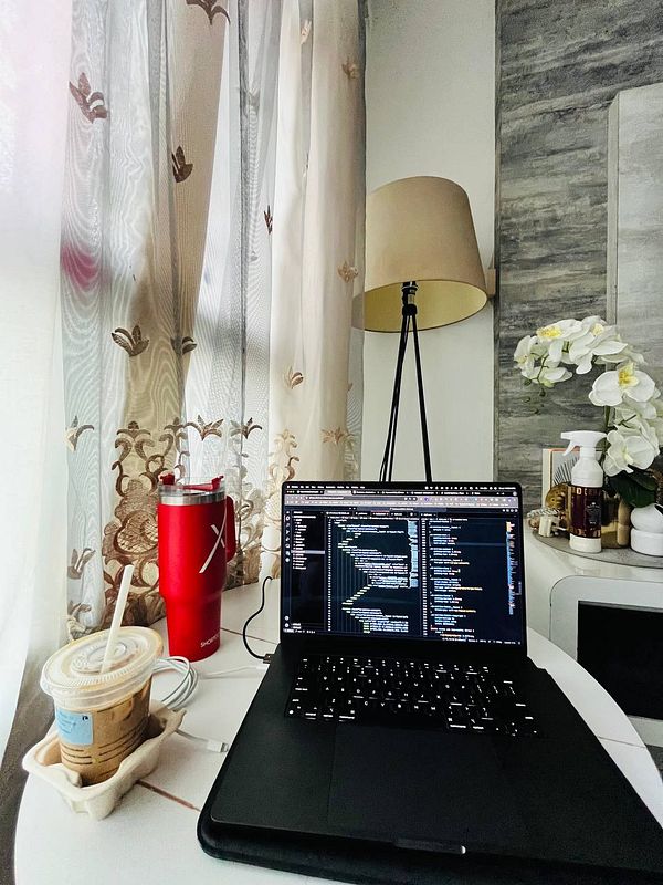 A cozy workspace featuring a laptop, coffee, and decorative elements.