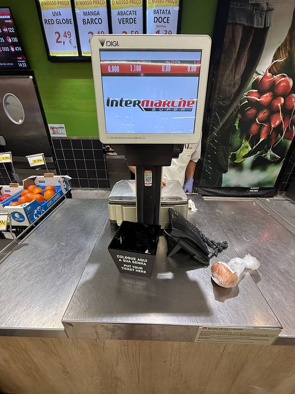 A self-service weighing station at a supermarket in Portugal, specifically designed for weighing produce like onions.