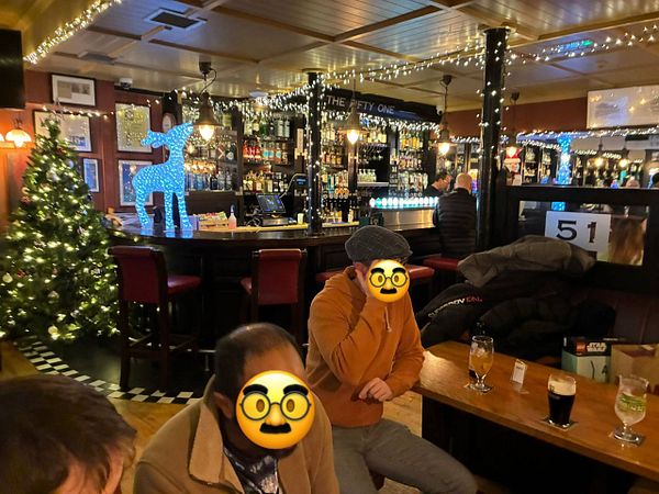 A cozy pub scene decorated for the holidays with friends enjoying drinks.