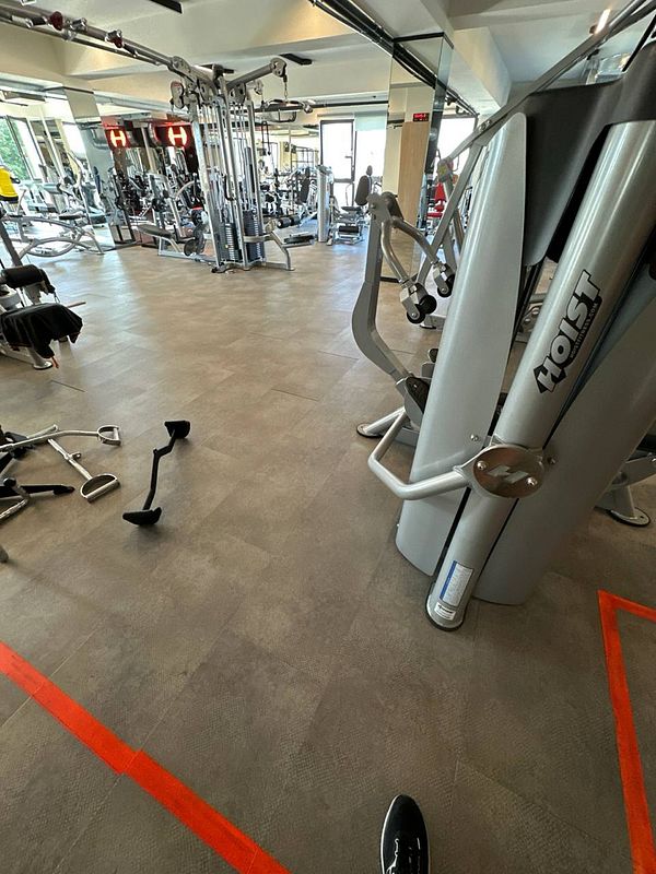 A well-equipped gym interior featuring various exercise machines and weights.