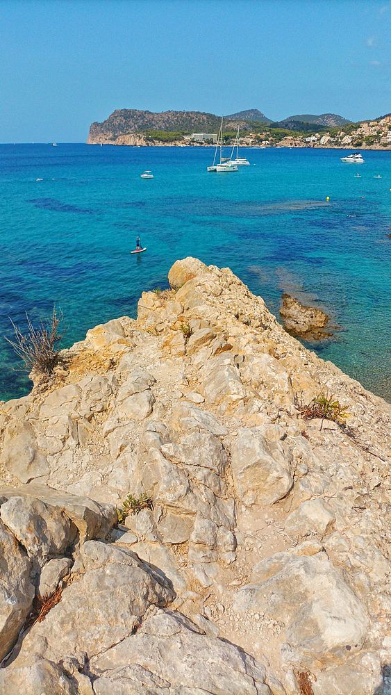 A scenic coastal view featuring clear turquoise waters and rocky terrain.