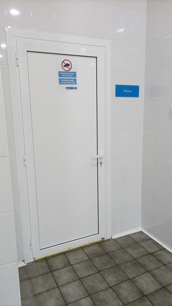 A clean, tiled area featuring a door labeled for a swimming pool.