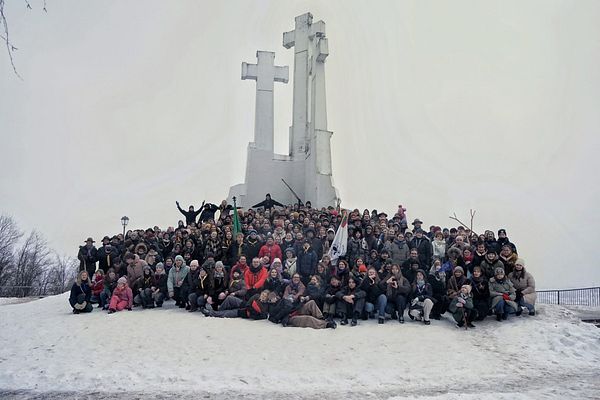 A group of Scouts in uniform stand together in an outdoor park setting celebrating Robert Baden-Powell's birthday.