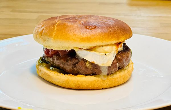 A delicious burger with a juicy patty and toppings on a toasted bun.