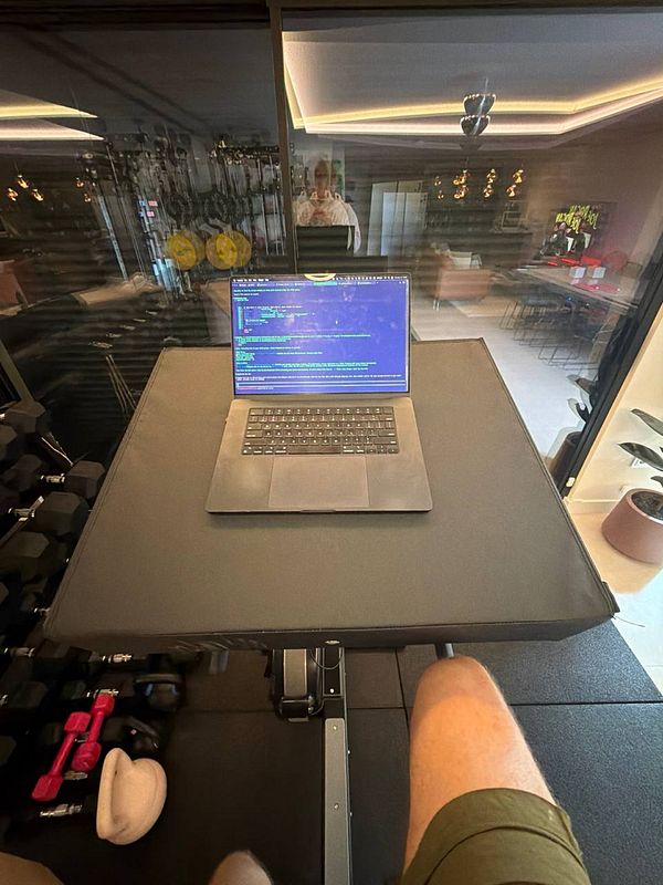 A woman in gym attire is running on a treadmill, with gym equipment and posters visible in the background.