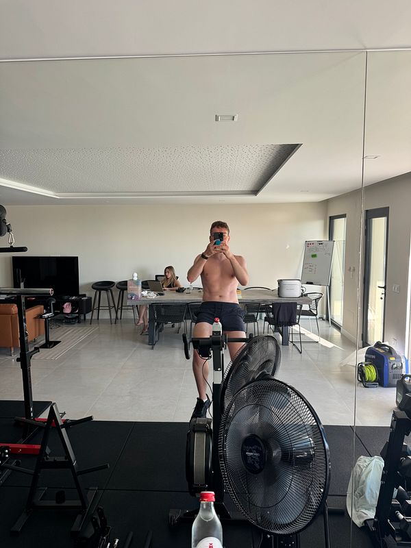 A person is taking a selfie in a home gym setting.