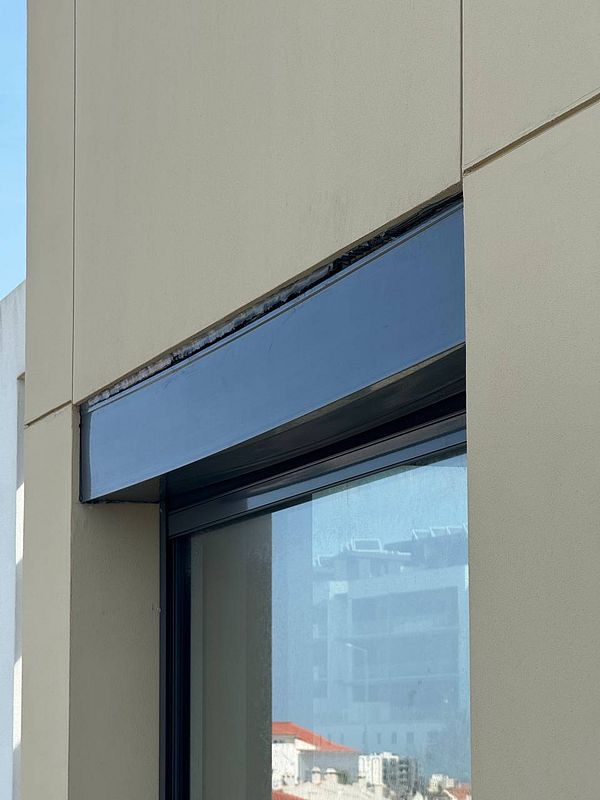 The image depicts a close-up view of electric blinds partially lowered in a window frame.