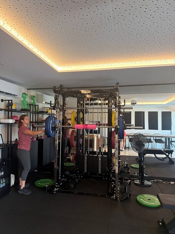 A gym locker room with an open locker displaying workout clothing and gear.