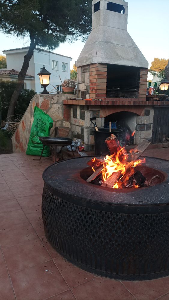 A cozy outdoor BBQ setup featuring a stone grill and a fire pit.