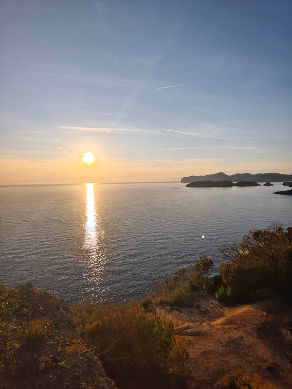 A stunning sunset view over a cityscape with silhouetted buildings and vibrant colors in the sky.