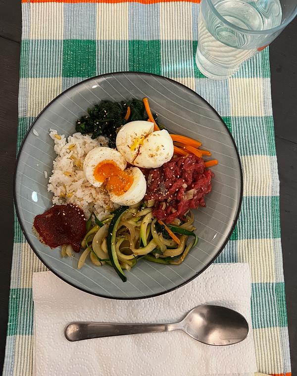 A beautifully arranged plate of Yukhoe Bibimbap featuring various colorful ingredients.
