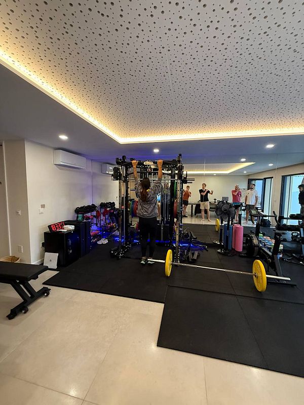 A group workout session is taking place in a well-equipped home gym.