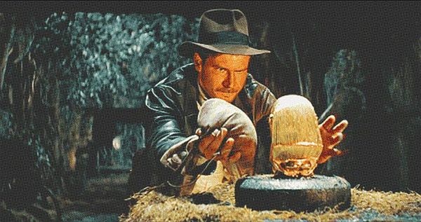 A scene from an adventure film featuring a character carefully handling a golden artifact.