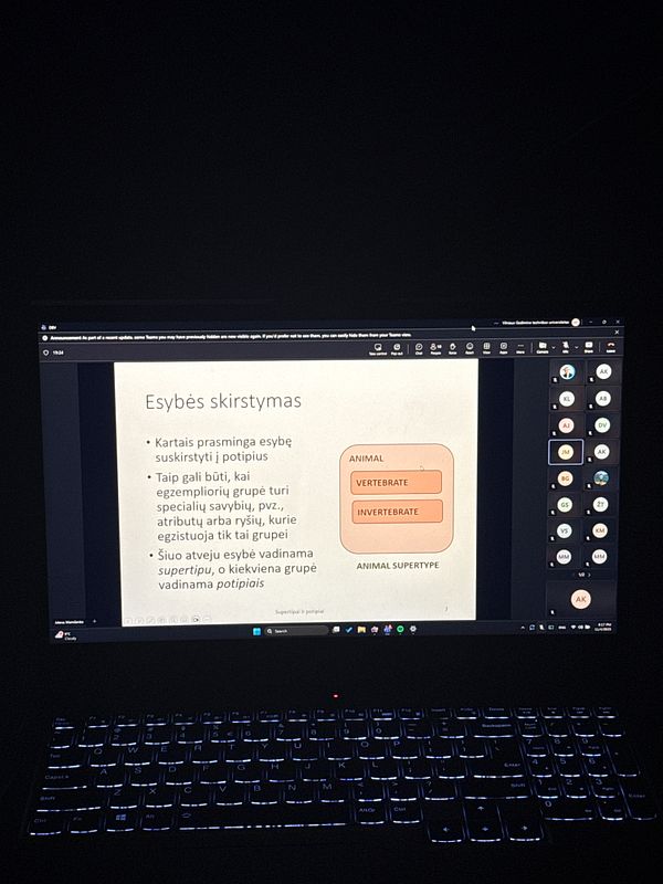A laptop screen displays a lecture on animal classification in a dimly lit environment.