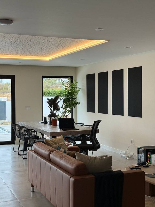 A modern coworking space featuring acoustic tiles, plants, and a stylish interior.