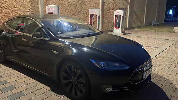 A black Tesla Model S is parked at a charging station in Germany.